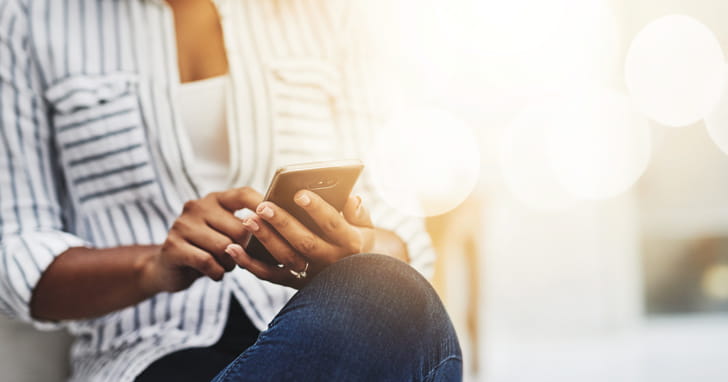 Young woman holding a cell phone in hands